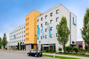 um carro estacionado em frente a um edifício em ibis budget Muenchen Ost Messe em Aschheim