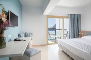 a bedroom with a bed and a view of the ocean at Zephyros Hotel in Myrties