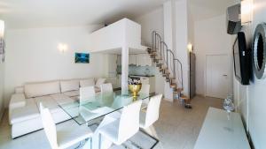 ein Esszimmer mit einem Glastisch und weißen Stühlen in der Unterkunft Villa Antonio in Novalja