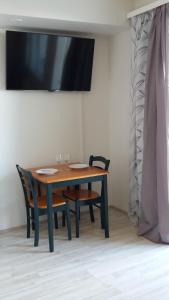 a wooden table with two chairs and a television at New nice apartment in Vaasa