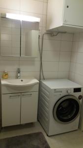 a bathroom with a washing machine and a sink at New nice apartment in Vaasa