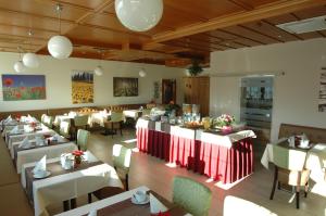 بنسيون ويبر في فيينا: غرفة طعام مع طاولات بيضاء وكراسي وحارق طاولات