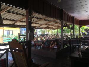 two people sitting on a couch in a restaurant at Dalom Guesthouse in Don Det