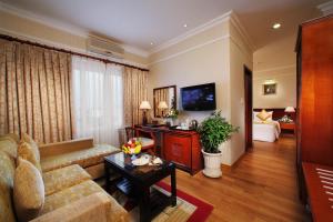 a living room with a couch and a tv at First Hotel in Ho Chi Minh City