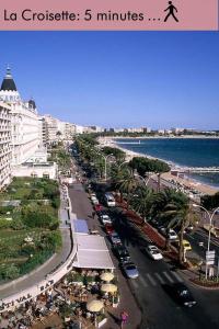 a city street with cars parked next to the ocean at Amazing Studio Cannes Center in Cannes