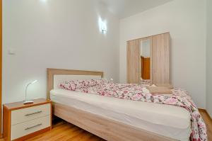 a bedroom with a bed with a dresser and a mirror at Apartment Zora & Natale in Pula