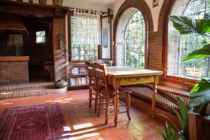 une table et des chaises dans une pièce avec fenêtres dans l'établissement Ca' delle palme, à Martellago