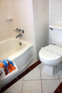 a bathroom with a toilet and a bath tub and a toilet at Key West Hotel in Wildwood