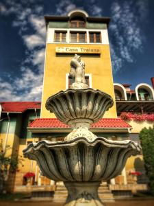 a fountain in front of a building with a tower at Casa Traiana in Alba Iulia