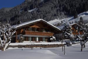 a large log cabin with snow on the roof at Ferienwohnungen Mueller in Oberstdorf