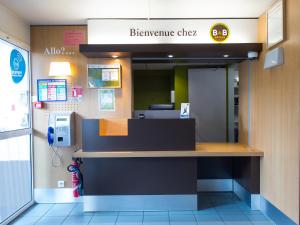 una entrada a una clínica benzina con un teléfono público en B&B HOTEL Tours Nord 1 Val de Loire, en Tours