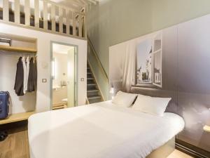 une chambre avec un lit blanc et un escalier dans l'établissement B&B HOTEL Tours Nord 1 Val de Loire, à Tours 31 autres photos
