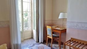 a room with a desk with a lamp and a window at Hotel Roma e Rocca Cavour in Turin