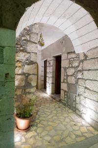 un arco en un edificio de piedra con una maceta en Casa Arco Antico, en Caltabellotta
