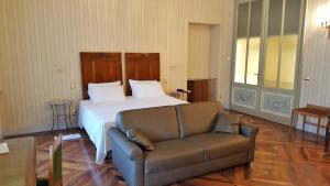 a bedroom with a bed and a couch at Hotel Roma e Rocca Cavour in Turin