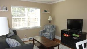 a living room with a couch and a tv and a chair at The Better Half Duplex in Charlotte