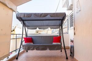 - un lit sur un balcon avec des oreillers rouges dans l'établissement Lovely Petit Apt in Athens, à Athènes