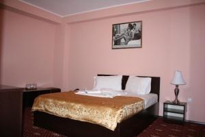 a bedroom with a bed with a picture on the wall at Hotel Austin in Constanţa