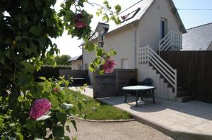 a house with a table and a fence and flowers at Lebraz 3 Appartement in Saint-Lunaire