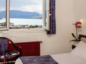 a bedroom with a window with a view of the water at Logis Hotel Eden Lac in Savines