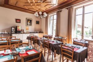 un comedor con mesas, sillas y ventanas en La Grande Eperviere en Barcelonnette