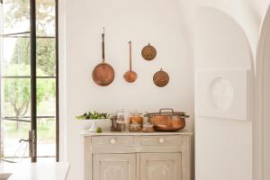 a kitchen with copper pots and pans on the wall at Critabianca - Masseria in Salento in Cutrofiano