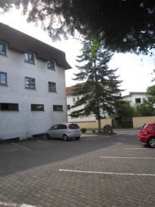 une voiture garée dans un parking à côté d'un bâtiment dans l'établissement Hotel Princess, à Rodenbach