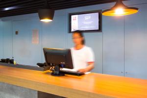 a man standing at a counter with a computer at ibis Cascavel in Cascavel