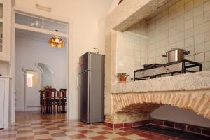a kitchen with a refrigerator next to a brick oven at Lisbon Calling Rooms & Studio in Lisbon