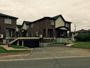 a large brick house with a garage in front of it at Luxury Two Story Villa Unit C in Laval