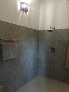 a bathroom with a shower and a towel at Paddy House Villa Home Stay in Tangalle