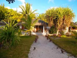 a resort with palm trees in front of a building at Residence Monique in Ile aux Nattes