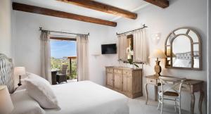 a bedroom with a bed and a desk and a mirror at Relais Villa Carola in Porto Cervo