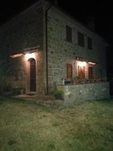 a stone building with two windows at night at Villa Il Corniolo in Morra