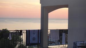 a view of the ocean from a balcony with towels on a fence at Apartmani More in Sveti Stefan