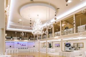 a large ballroom with a chandelier and tables in it at Hotel i Restauracja Jan in Bełchatów