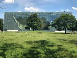 ein Gebäude mit einem Grasfeld davor in der Unterkunft Apartament Karmelicka 19 Muzeum Polin in Warschau