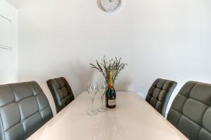 a table with wine glasses and a clock on the wall at Apartments Relax in Veli Lošinj