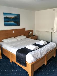 a bedroom with a large bed with two towels on it at The Beach Motel in Trearddur
