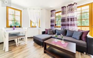 a living room with a couch and a table at Wonder Home - Apartamenty blisko centrum Karpacza, tuż przy szlakach i stoku narciarskim - cicha okolica in Karpacz