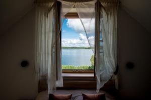 a bedroom with a window with a view of a lake at Prie Žiedo in Trakai
