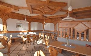a restaurant with wooden ceilings and tables and chairs at Hotel Ausseerland in Bad Mitterndorf