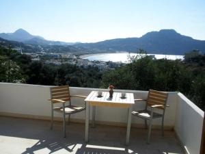 a table and two chairs on a balcony with a view at Olive Grove in Plakias