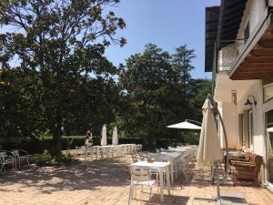 a row of tables and chairs with a white umbrella at Agriturismo Valdolivo in Cogoleto