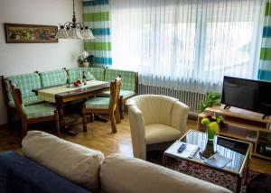 uma sala de estar com um sofá e uma mesa em Ferienwohnungen Anna em Bad Birnbach