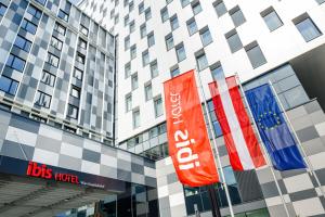 a tall building with flags in front of it at ibis Wien Hauptbahnhof in Vienna