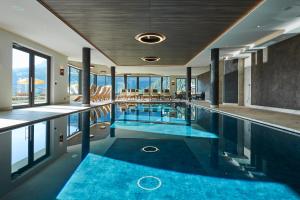 a swimming pool with blue water in a building at Residence La Selva in Selva di Val Gardena