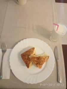 un plato blanco con dos rebanadas de pizza en una mesa en Family Hotel Panorama, en Chiflik 27 fotos más