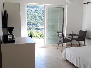 a room with a bed and a table and chairs and a window at Villa Marica in Neum