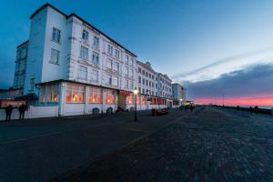 a building on the side of a street at dusk at Strandhotel Hohenzollern in Borkum